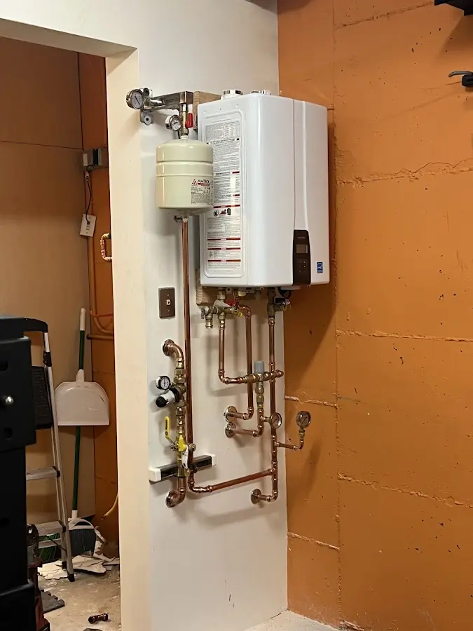 Plumbing technician inspecting water heater connections in Cross Mountain